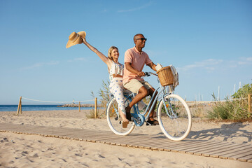 Loving couple riding bicycle on beach