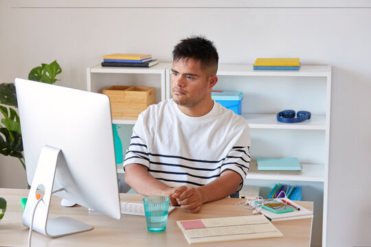 Down syndrome man working on computer