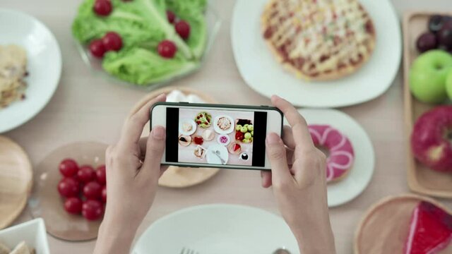 Net idol and take picture for review food. Women use mobile phones to take pictures of food or take live video on social networking applications. Food for lunch looks appetizing. 