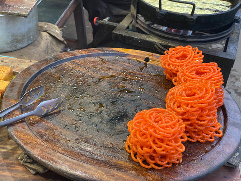 Preparing and selling Jilaibi,a popular sweet in a shop