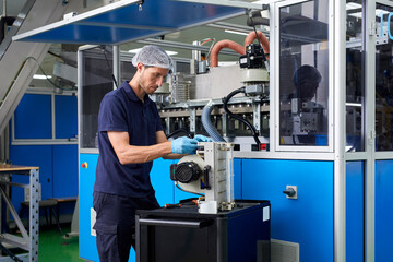 Man repairing industrial machine in factory