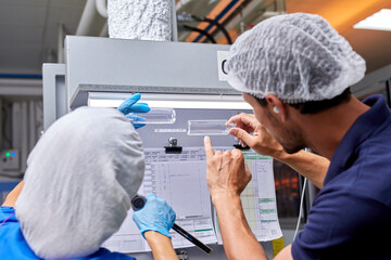 Coworkers checking quality of plastic bottles