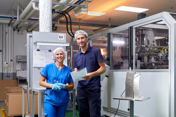 Happy factory workers looking at camera