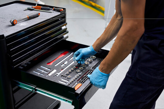 Mechanic with tool cabinet at factory