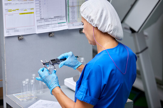 Woman using digital caliper at factory