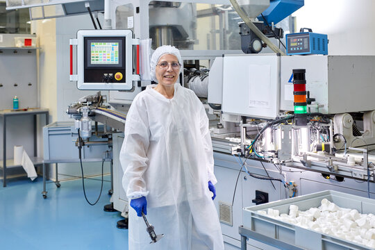 Cheerful factory worker near industrial machine