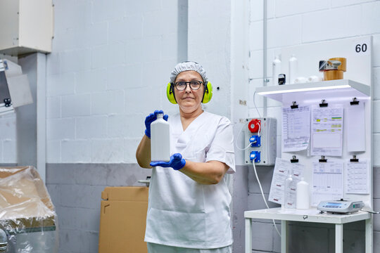 Worker with plastic bottle at factory