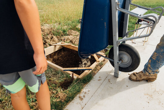 Man dumping material from wheelbarrow. 