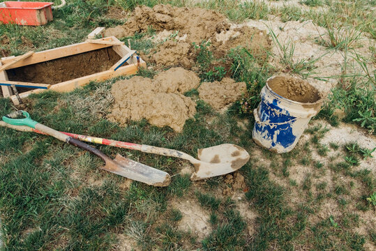 Dirty tools laying on the ground. 