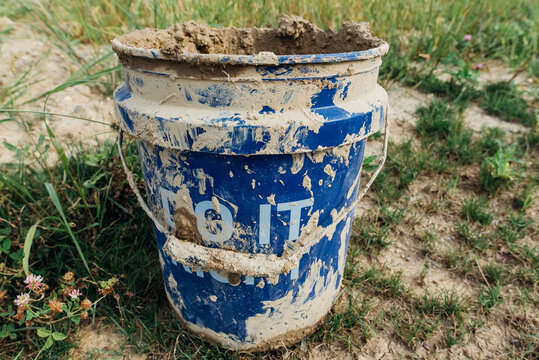 Muddy blue bucket. 