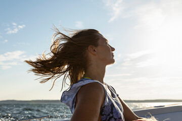Woman Riding in Boat with Hair blowing 