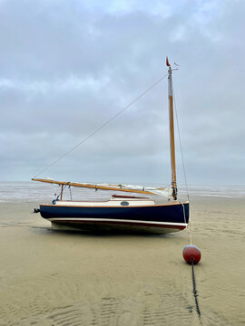 Small sailboat beached at low tide