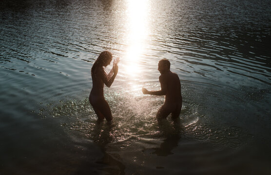 Naturist couple during a war of water
