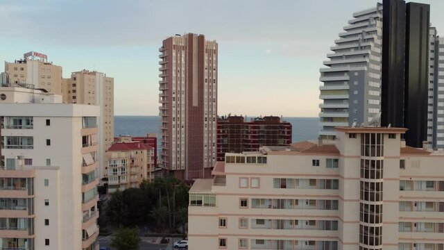 Drone clip through the rooftops of apartment buildings and hotels in the coastal area  in the town of Calpe in Spain