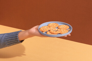Hand holding plate of biscuits