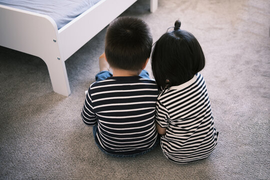 Mixed Asian Toddlers Reading A Book Together