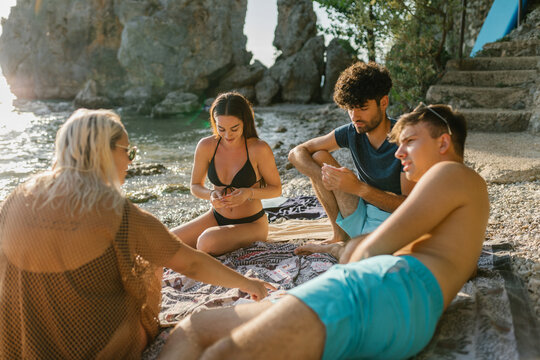 Friends Playing Cards At The Beach 