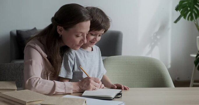 Mom patiently teaching and explaining to the child how to do homework and learn to count and solve problems. The process of homeschooling a preschooler pupil learning.