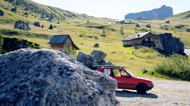 Tiny red car goes surfing / camping in the mountains