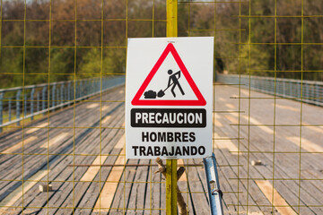 Men working sign in spanish
