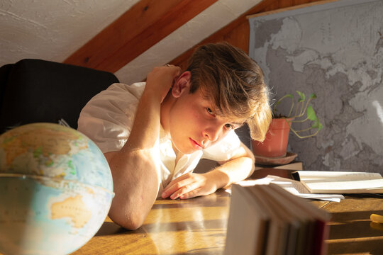 Portrait of a student sitting on his desk looking at the camera