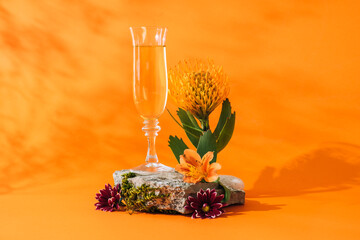 Glass of champagne on orange background