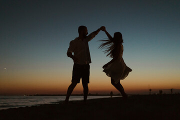 Silhouette of a couple dancing on the beach
