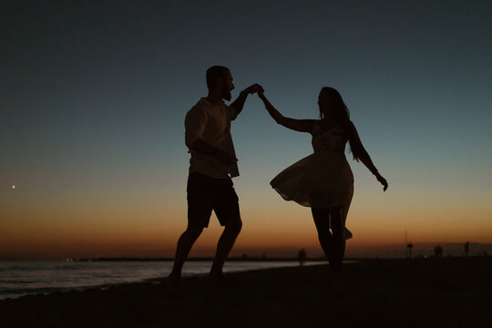 Couple dancing on the beach at sunset
