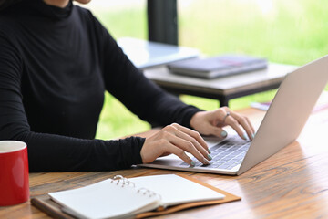 Cropped shot stylish woman working with laptop computer.