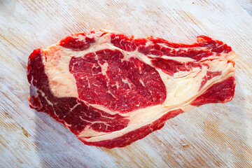 Raw beef entrecote steak ready for cooking on wooden surface. High quality photo
