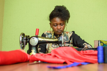 An African female tailor, fashion designer or dress maker, making stylish and fashionable clothes...