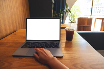 Fototapeta premium Mockup image of a woman using and touching on laptop touchpad with blank white desktop screen