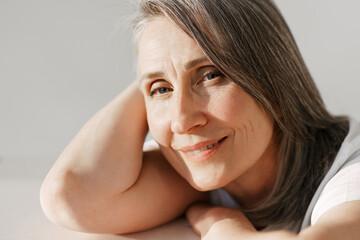 Fototapeta premium Grey senior woman in t-shirt smiling and looking at camera
