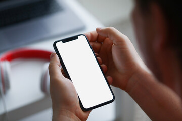 A man holds a smartphone, close-up of a hand with a phone.
