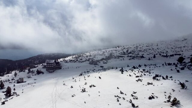 Bezbog hut in the  snow-covered Pirin mountains, Bulgaria, drone flight