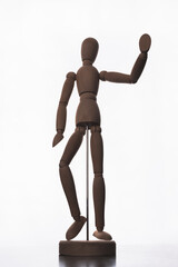 Swivel wooden model of a man on a metal stand with a raised hand waving in greeting.