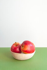 Bright red sweet apples on white and green background with copyspace for your text.