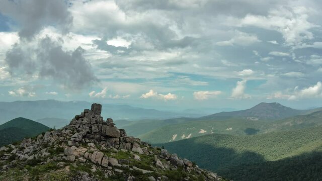 Pyramid of stones. Two-headed mountain. The flow of clouds. Timelapse. Summer.