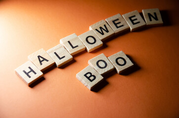 Obraz premium Inscription Halloween Boo outlined on orange background with copy space. Selective focus on Lettering Halloween. Celebration concept.