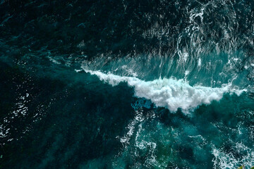 Fototapeta na wymiar Aerial view to seething waves with foam. Waves of the sea meet each other during high tide and low tide