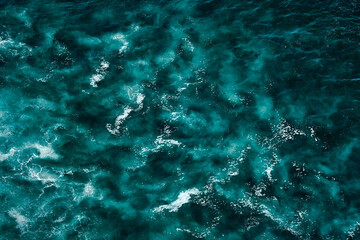 Fototapeta na wymiar Aerial view to seething waves with foam. Waves of the sea meet each other during high tide and low tide