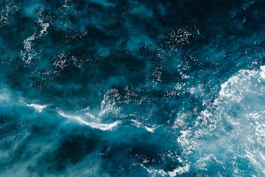 Aerial view to seething waves with foam. Waves of the sea meet each other during high tide and low tide