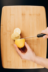 
lemon yellow on a wooden board for cutting in hand