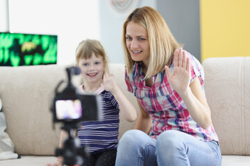 Mom and daughter record video greeting on camera