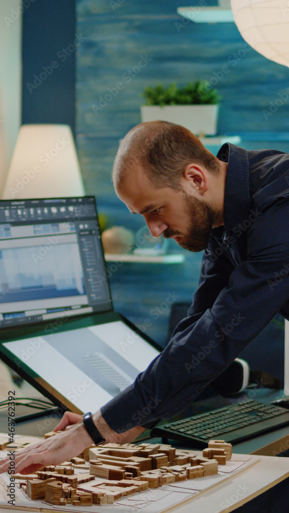 Aufkleber man with architect job working on building model with touch screen computer and maquette for constru