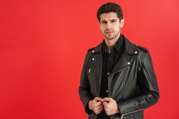 Young unshaven man wearing leather jacket looking at camera