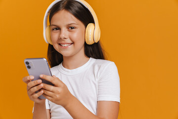 White brunette girl listening music with cellphone and headphones