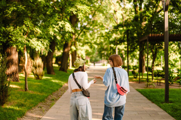 Fototapeta na wymiar Multiracial two women talking and gesturing while walking together