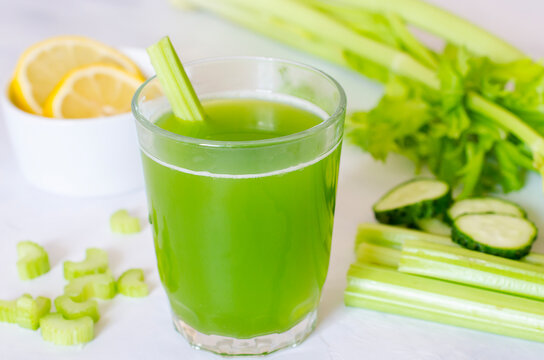 Green fresh celery and cucumber juice with lemon limtizers. Ingredients for a healthy drink, a glass of drink on a white background. Detox diet, pure organic food, with vegetables