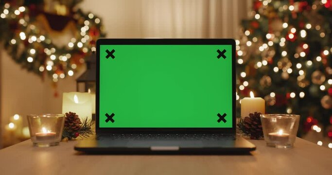 Merry Xmas eve wishing happy joy in blank laptop live video call, watching webcam, web page frame in good warm time winter season with gift on desk table and gold color tree light at night cozy home.